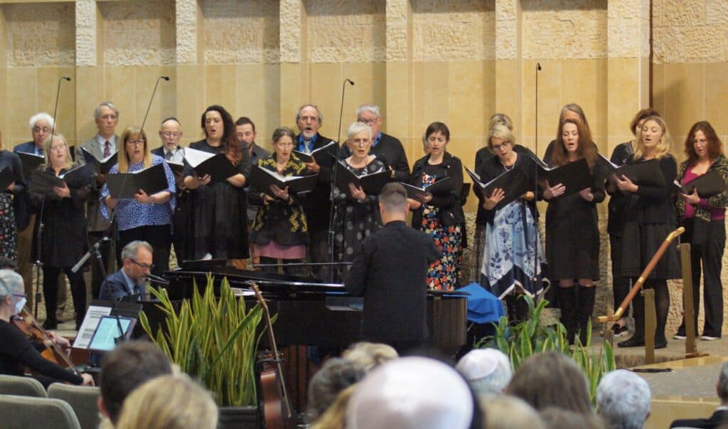 The adult choir sings on the bimah during a service.