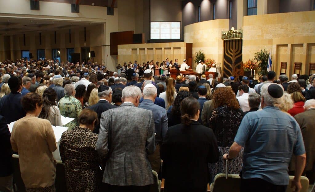 Congregants stand in the sanctuary during High Holy Days services
