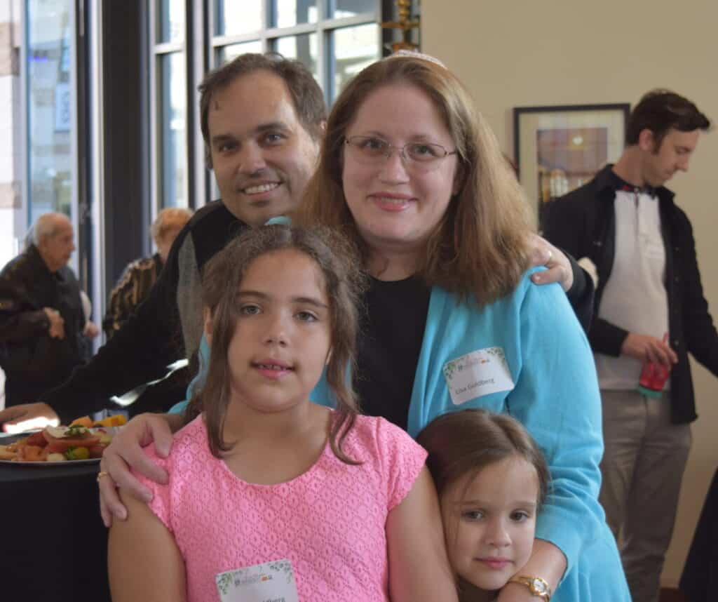 A family poses together during a new member shabbat celebration.