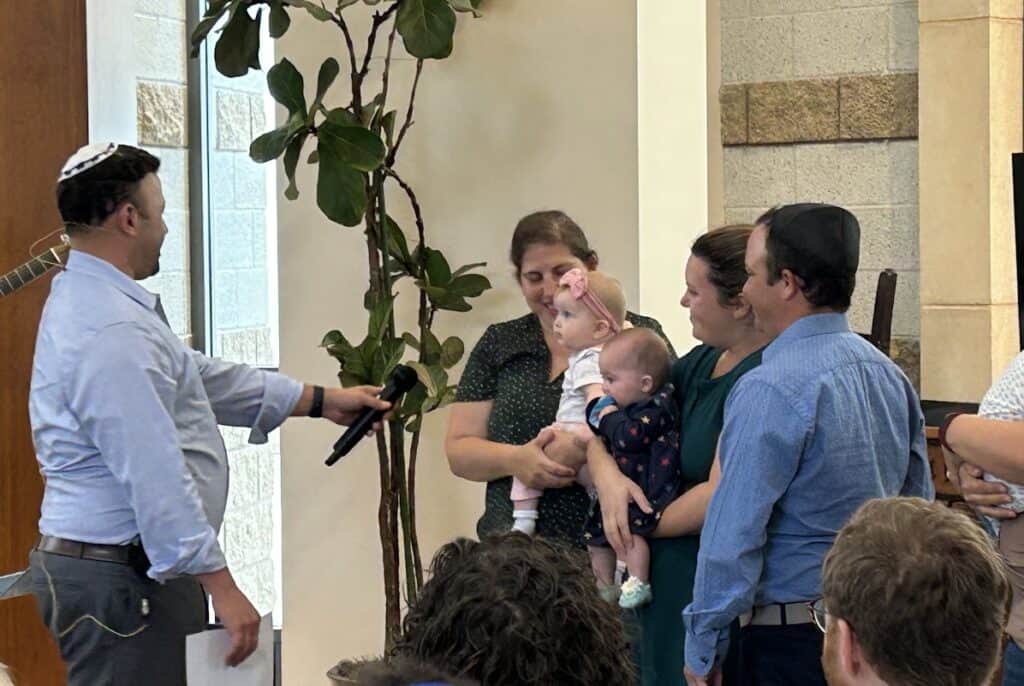 A young family introduces their children to the Rabbi