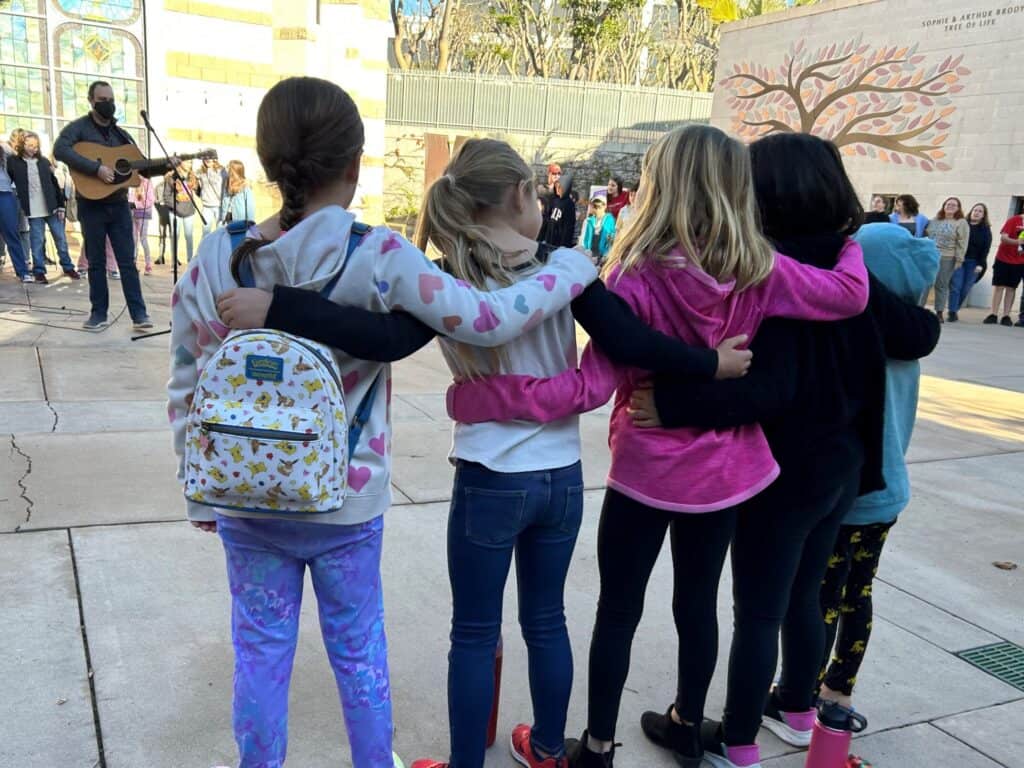 Religious school students stand arm-in-arm during morning drop off.
