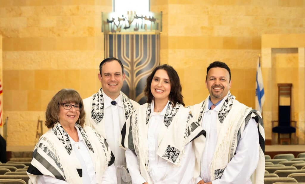 All four Beth Israel clergy members pose on the bimah in their white High Holy Days attire.