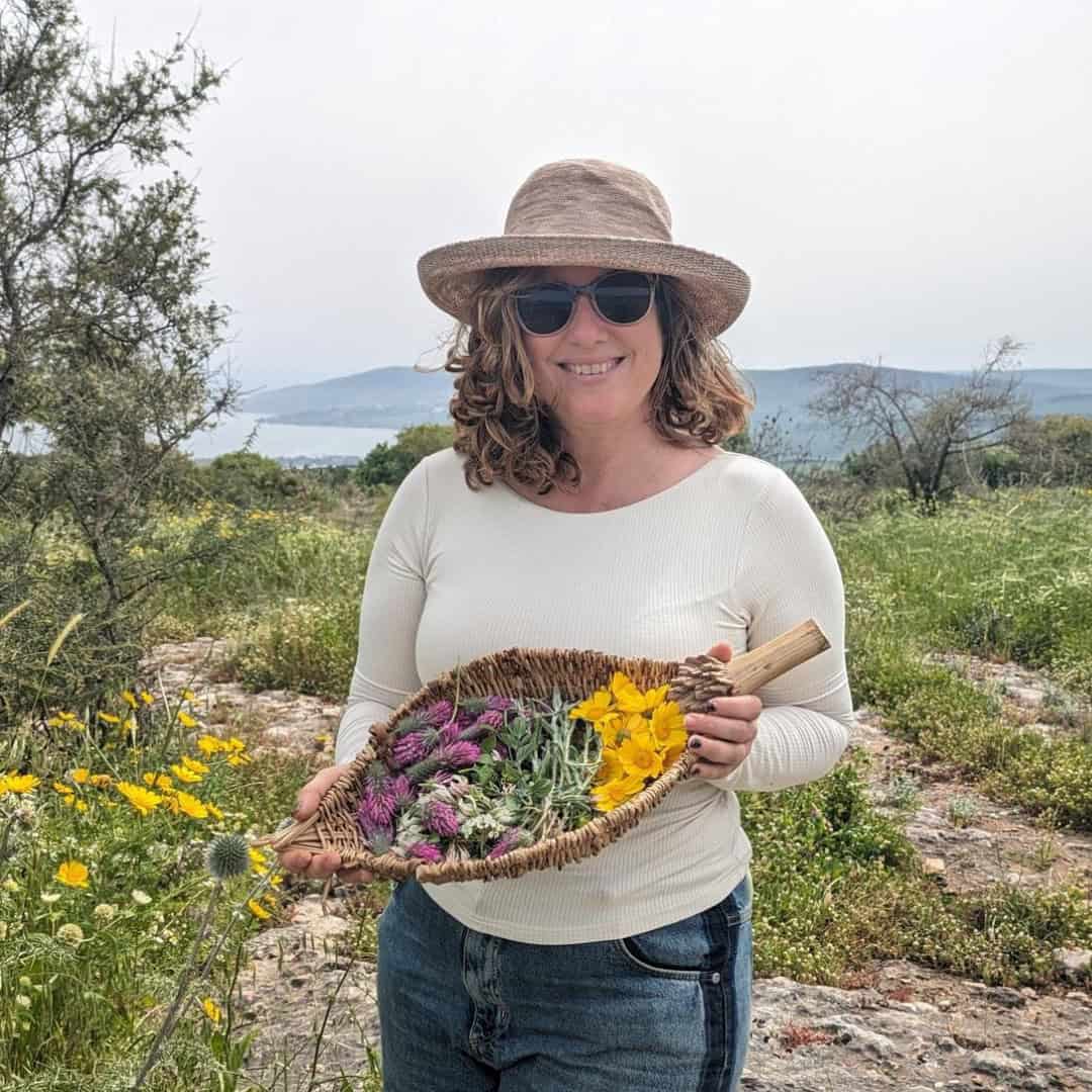 Gila Levitan Holds A Basket Of Fresh Flowers In Nature