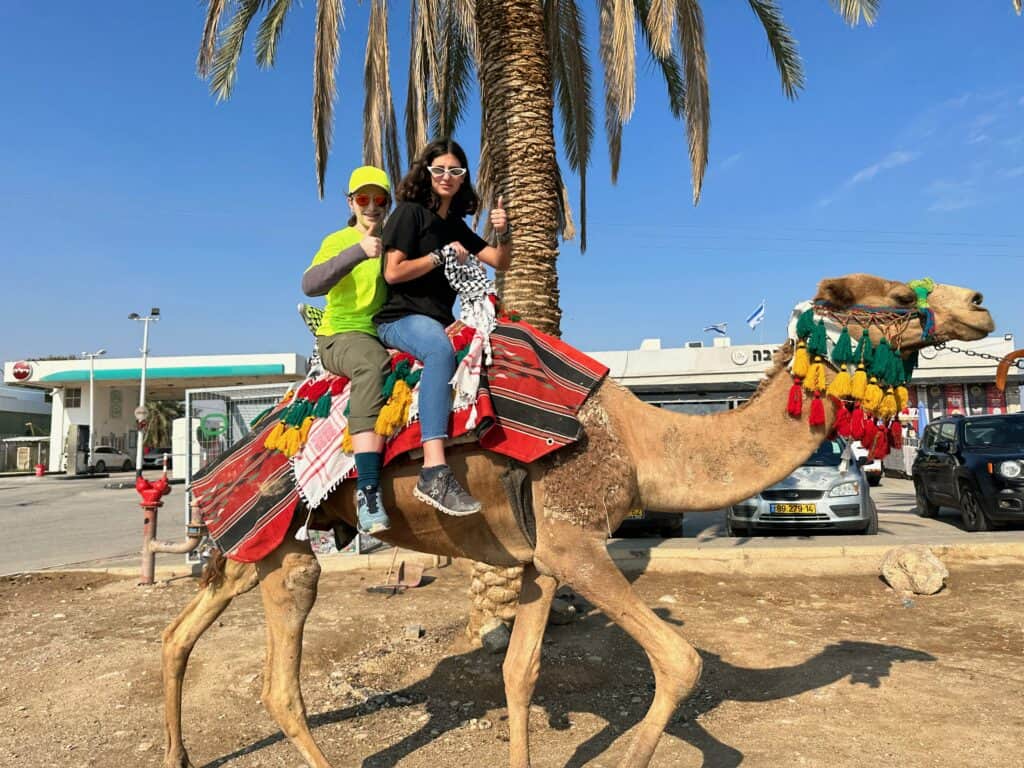 Two students ride a camel in Israel