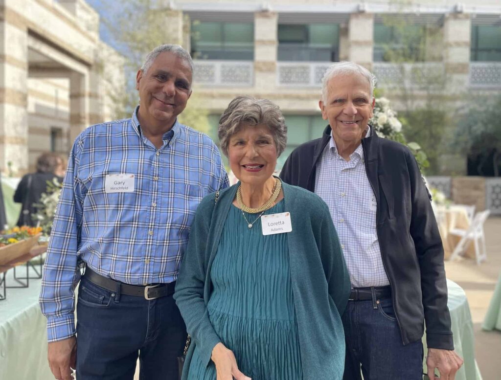 Three congregants pose at an event in the CBI courtyard