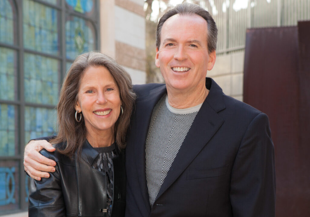 A mature couple stand together with arms around each other in the Beth Israel Courtyard.