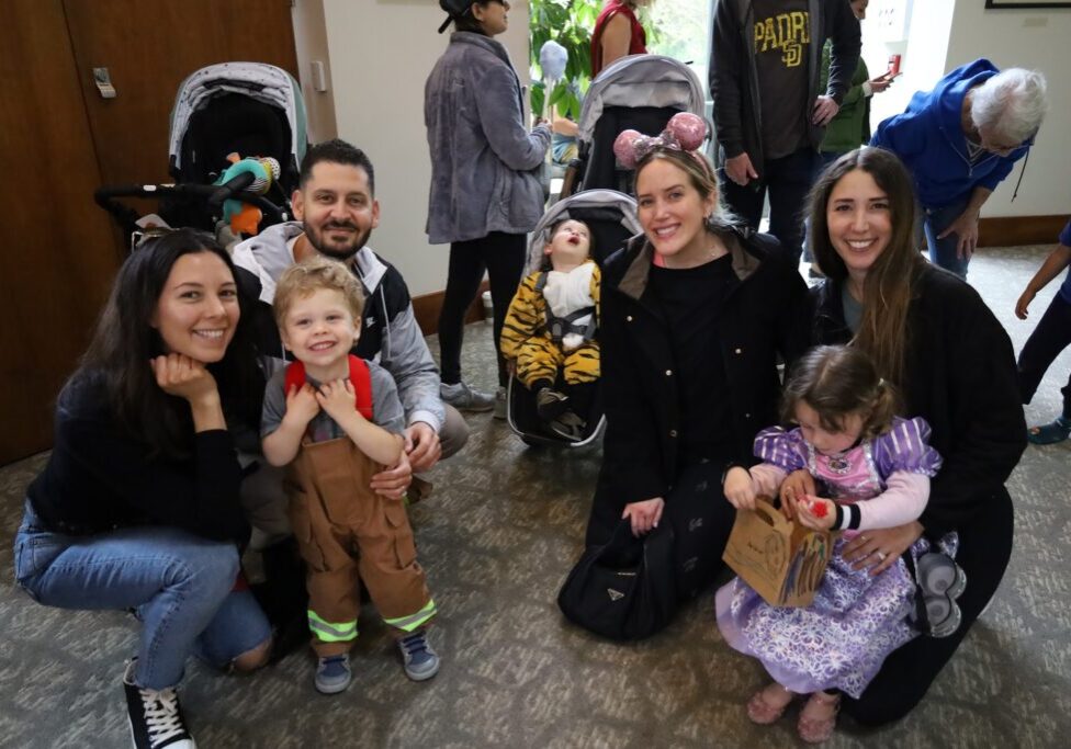Young families pose together during the CBI Purim Carnival