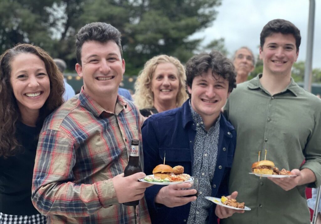 Group of people holding food on plates and smiling